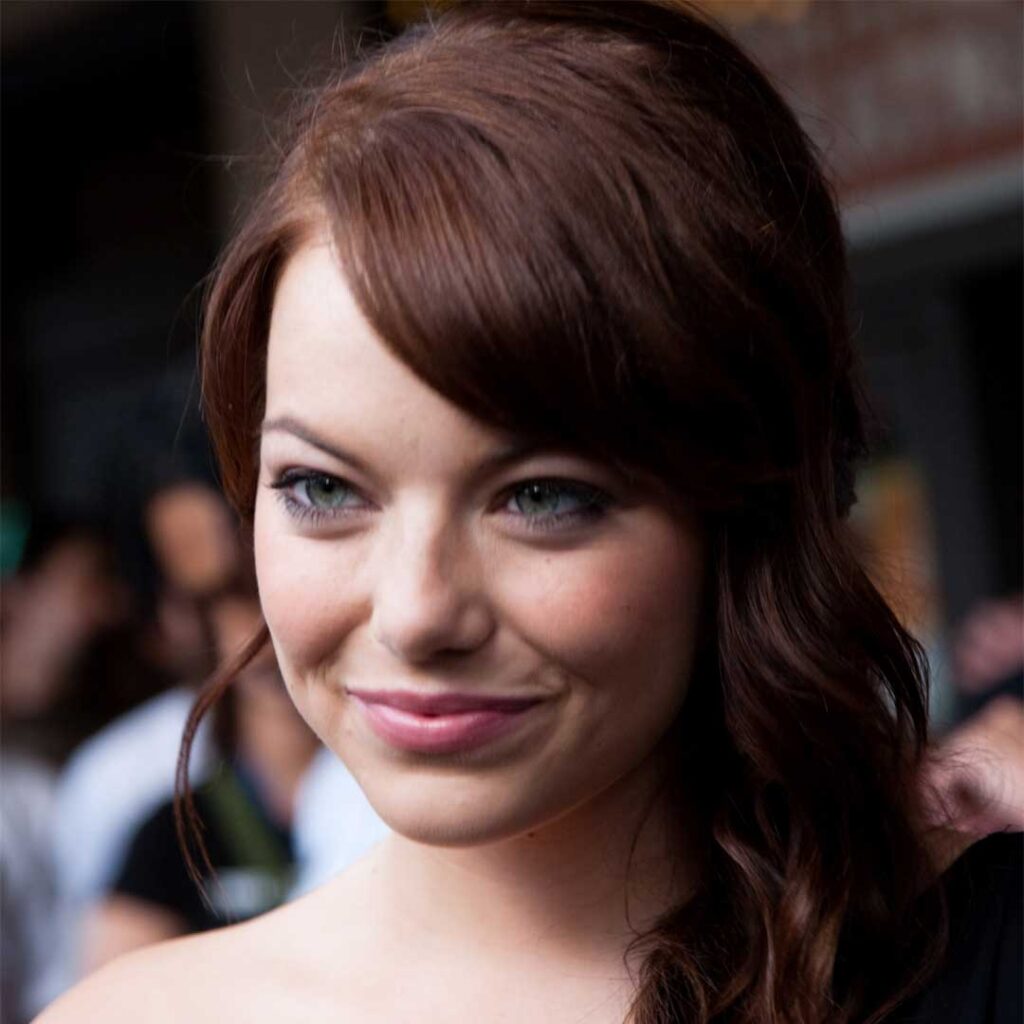 Emma Stone has a round face shape, characterized by soft features and a face that is as wide as it is long.