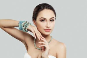 Elegant woman wearing matching blue gemstone necklace and bracelets, showcasing a harmonious jewelry look.
