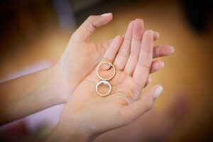 A pair of gold and silver rings placed delicately in a woman's hands, symbolizing care and preservation of jewelry.