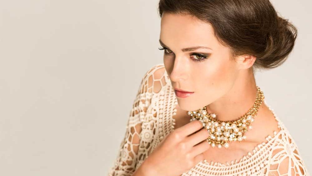 A poised woman wearing a statement pearl necklace, symbolizing self-worth and empowerment.