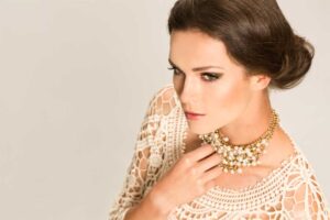 A poised woman wearing a statement pearl necklace, symbolizing self-worth and empowerment.