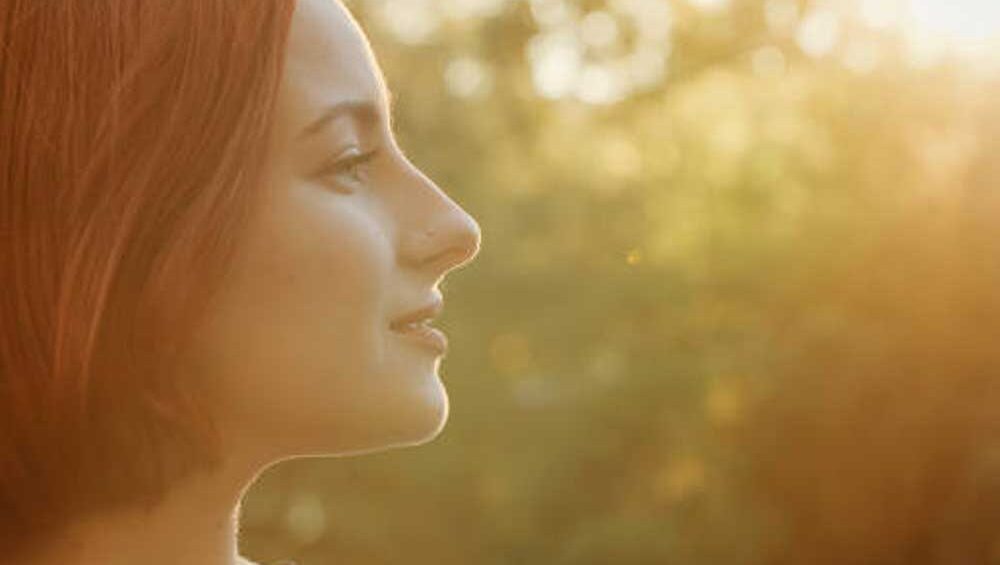 A serene woman looking toward the sunlight, symbolizing self-discovery and personal growth.