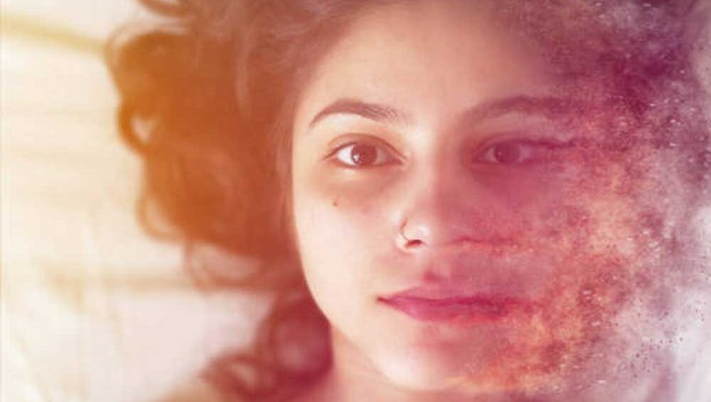 Woman lying in bed with ethereal light dissolving part of her face, symbolizing emotional and spiritual release.