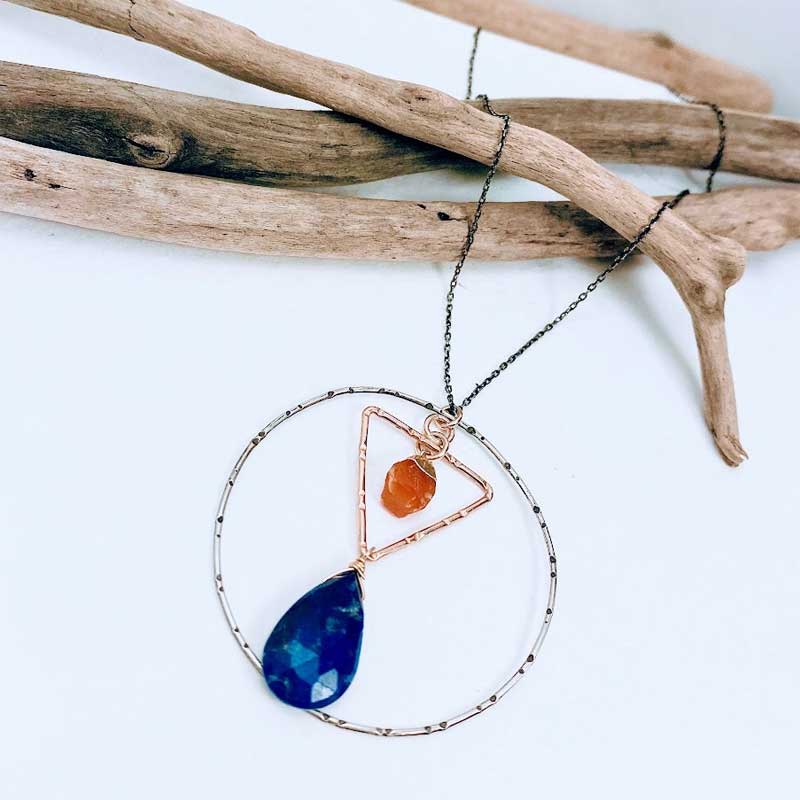 Mixed metal pendant necklace with lapis lazuli and carnelian gemstones framed in geometric shapes