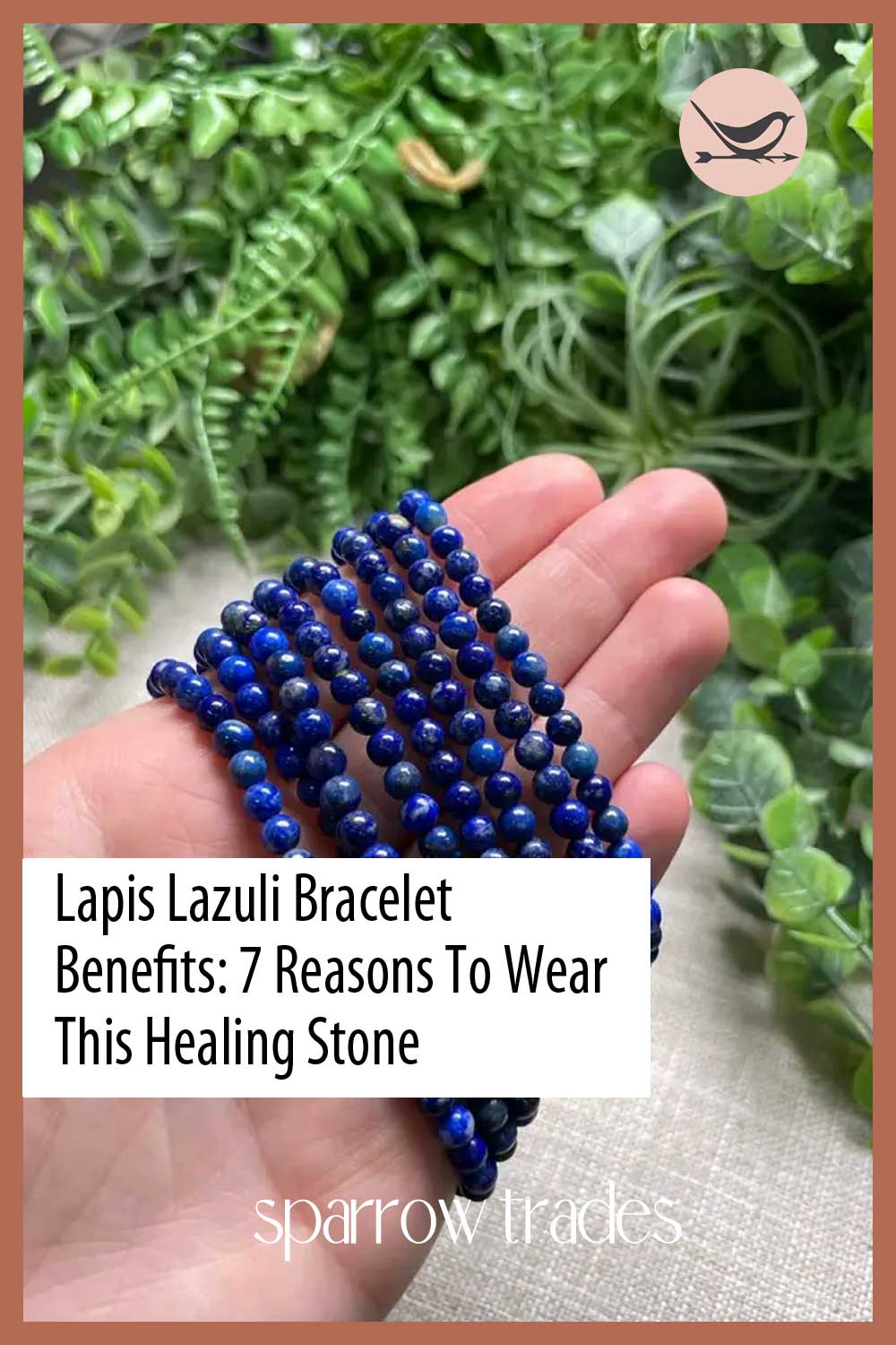 A hand holding several deep blue lapis lazuli beaded bracelets in front of a vibrant green background – promoting healing stone benefits.