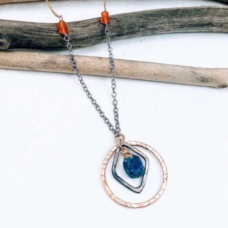 Handcrafted necklace with raw lapis lazuli, hammered gold and silver rings, and carnelian gemstone accents