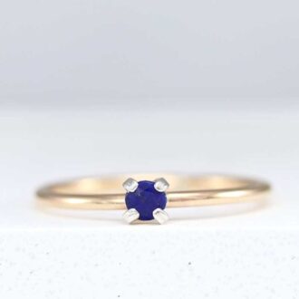 Dainty lapis ring featuring a small 3mm blue gemstone set on a thin polished band, displayed on a white background.