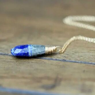 Natural Lapis Lazuli Strata Necklace wrapped in gold wire on wood surface