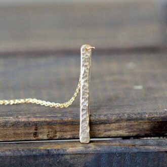Hammered vertical bar necklace in 14k gold fill on wooden surface