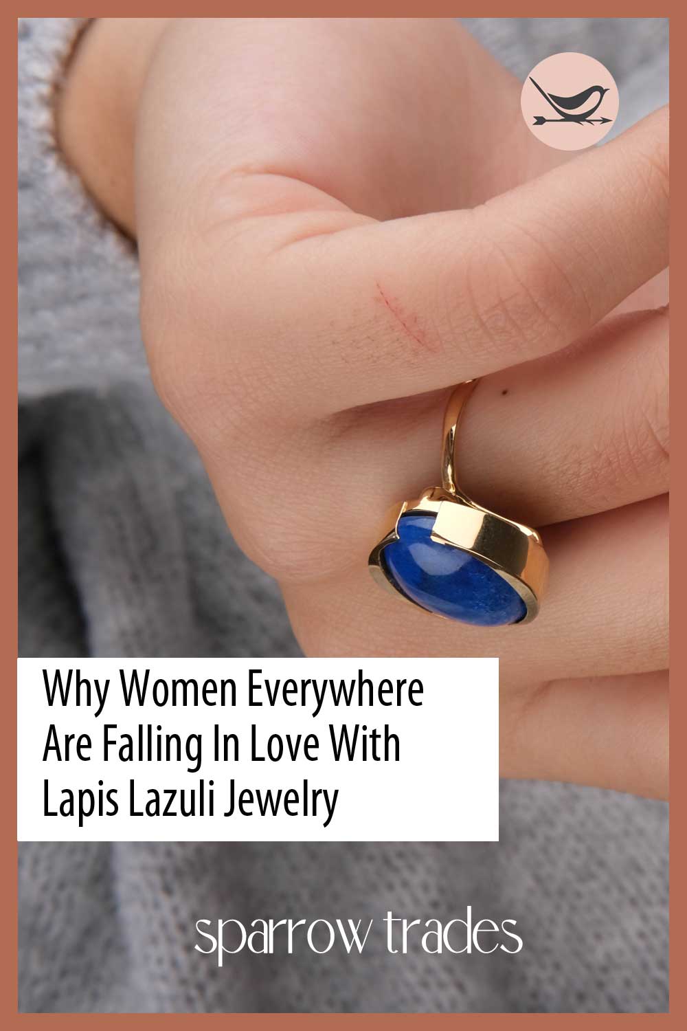 Close-up of a woman’s hand wearing a gold ring with a round lapis lazuli gemstone, overlaid with the text “Why Women Everywhere Are Falling In Love With Lapis Lazuli Jewelry” from Sparrow Trades.