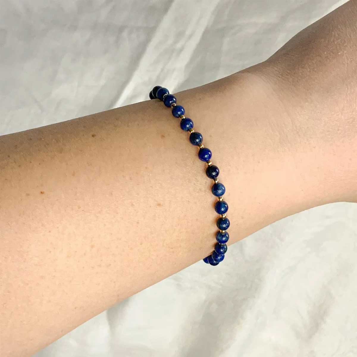 Lapis lazuli beaded bracelet with gold accents worn on wrist – Gather Brooklyn