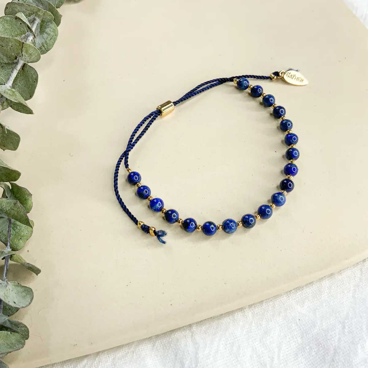 Adjustable bracelet with lapis lazuli beads and gold accents on navy cord by Gather Brooklyn