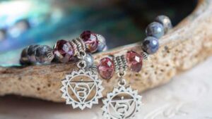 Close-up of chakra bracelets with healing crystals and silver chakra symbols for spiritual balance