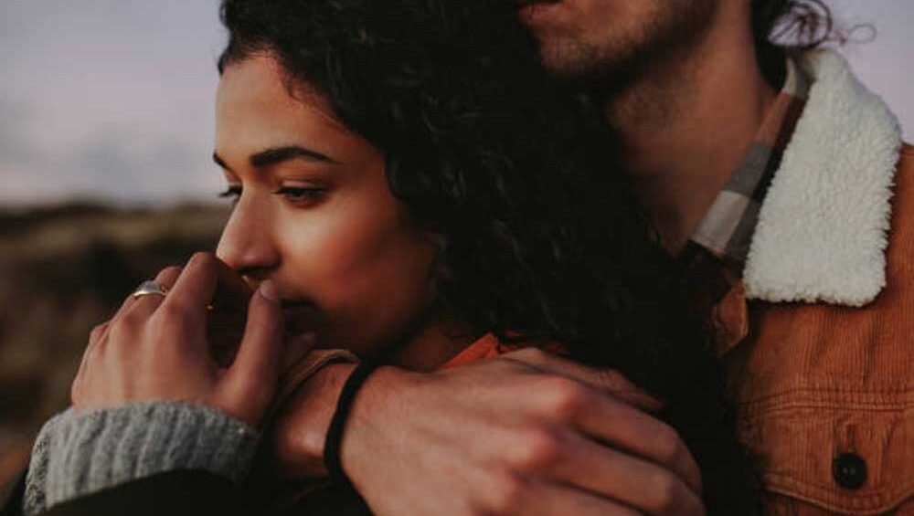 Woman being held in a comforting embrace, reflecting deep emotional connection and empathy