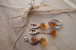Flat lay of Scandinavian amber jewelry on natural wood, showcasing Nordic minimalism and craftsmanship
