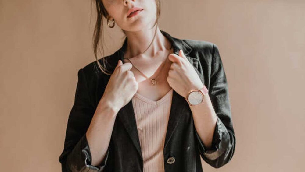 Woman wearing a necklace and blazer, expressing identity through jewelry