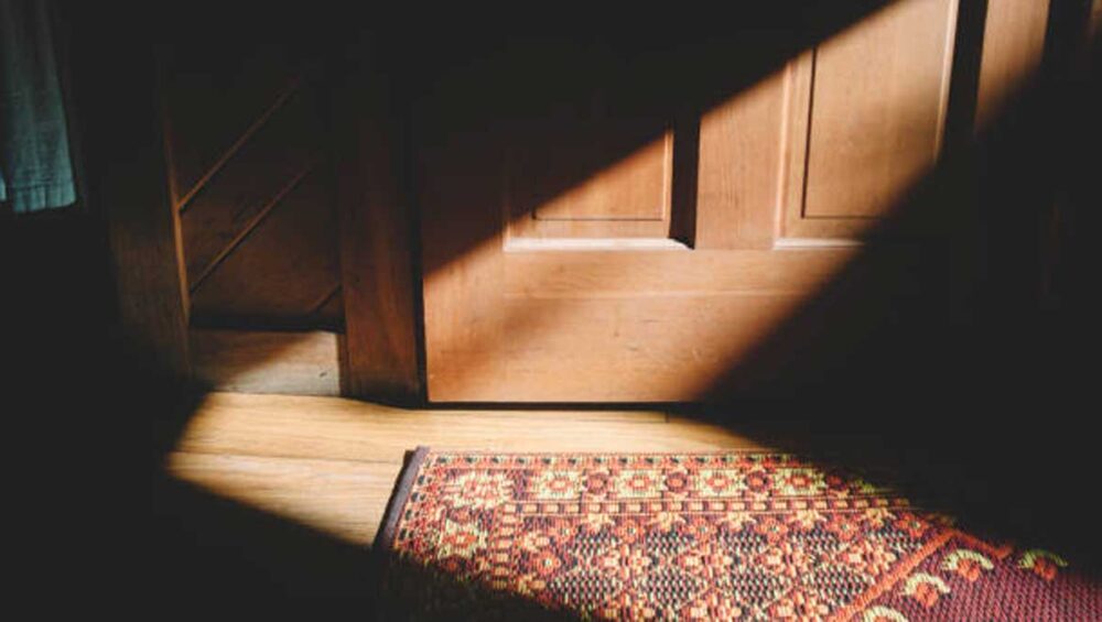 Locked wooden door with sunlight casting shadows, symbolizing personal boundaries and protecting peace from a narcissistic parent.
