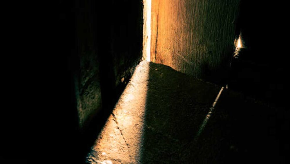 Sunlight peeking through a closed interior door, symbolizing boundaries and emotional erasure