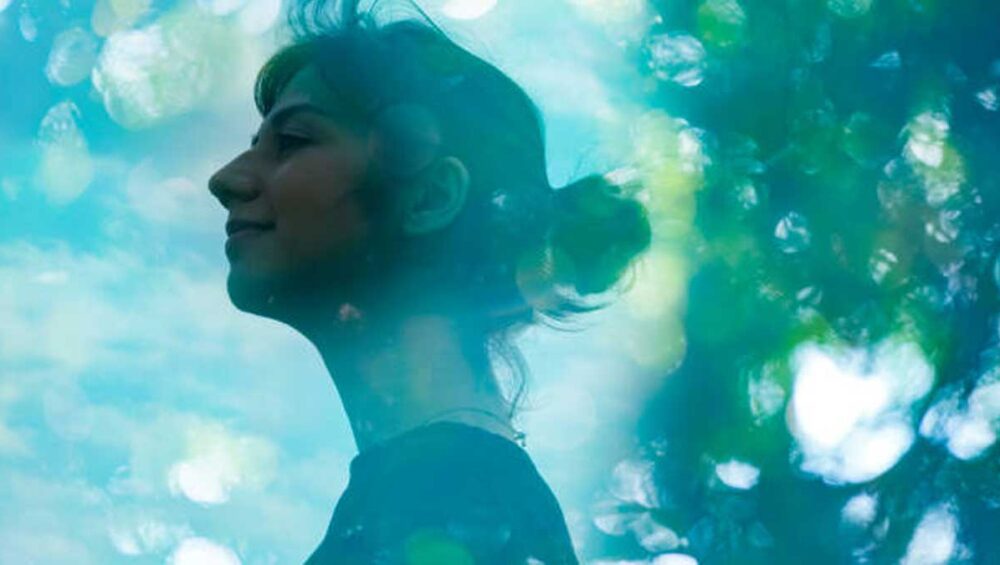 A calm woman surrounded by soft light and nature, symbolizing empowerment and emotional resilience gained by setting boundaries with narcissists.