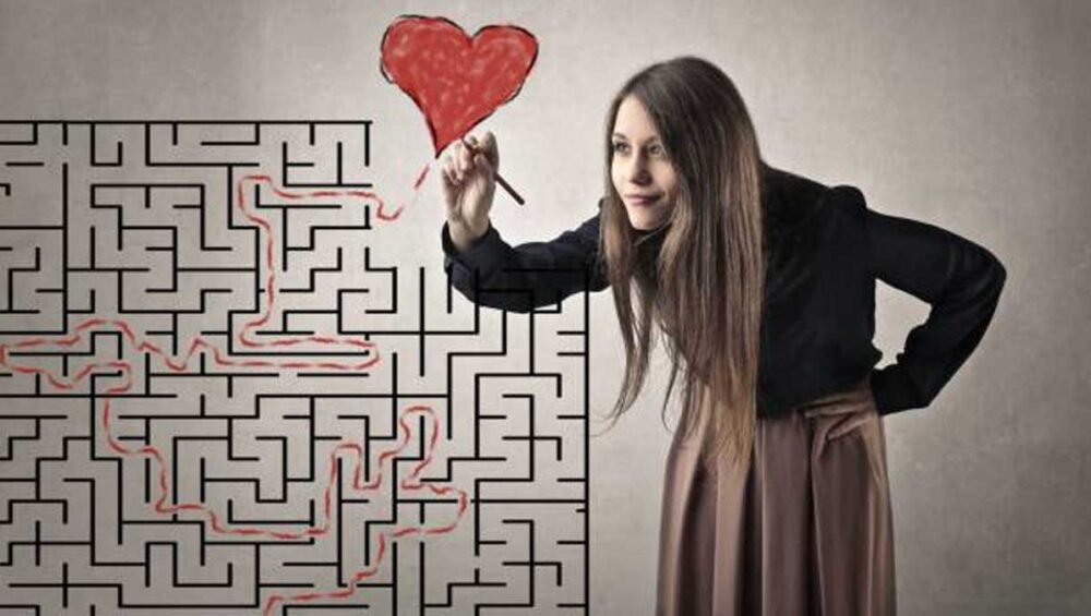 Woman tracing a path through a maze and drawing a heart, symbolizing healing from toxic family roles
