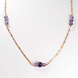 Gold link chain necklace with graduated amethyst beads at the center and side stations
