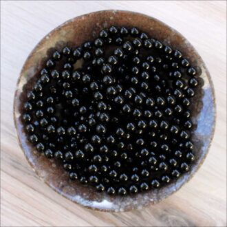 Black Onyx beaded bracelets displayed in a bowl.