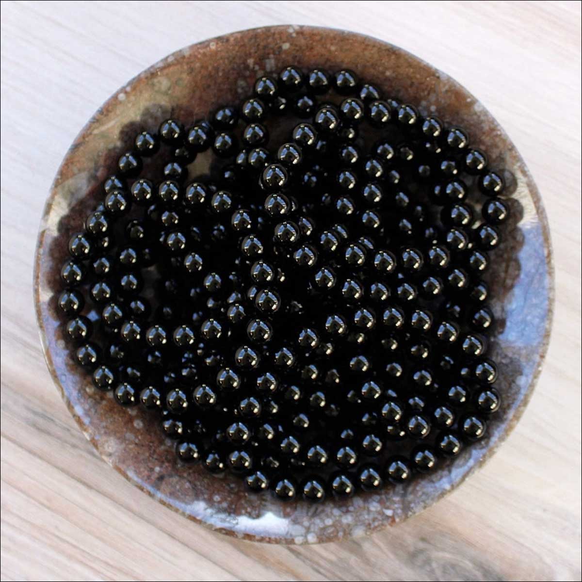 Black Onyx beaded bracelets displayed in a bowl.