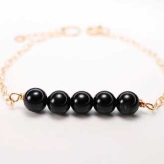 Black Onyx Genesis Bracelet with gold-filled chain and five onyx beads.