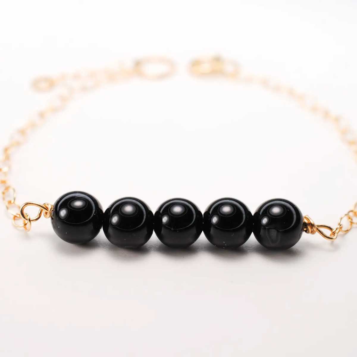 Black Onyx Genesis Bracelet with gold-filled chain and five onyx beads.