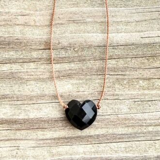 Black Onyx faceted heart cord necklace with sterling silver findings on a light brown cord.