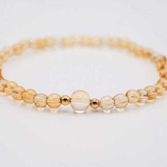 Citrine beaded stretch bracelet with a larger 6 mm center bead and two gold-filled accents