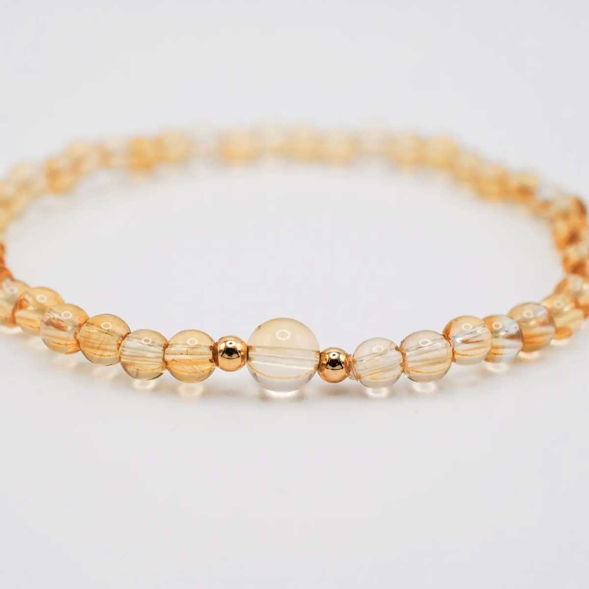 Citrine beaded stretch bracelet with a larger 6 mm center bead and two gold-filled accents