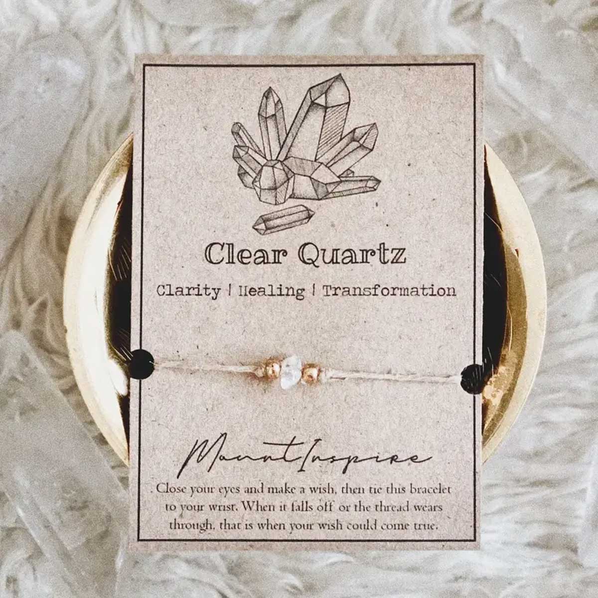 Clear quartz crystal wish bracelet with hemp cord and gold beads on inspiration card