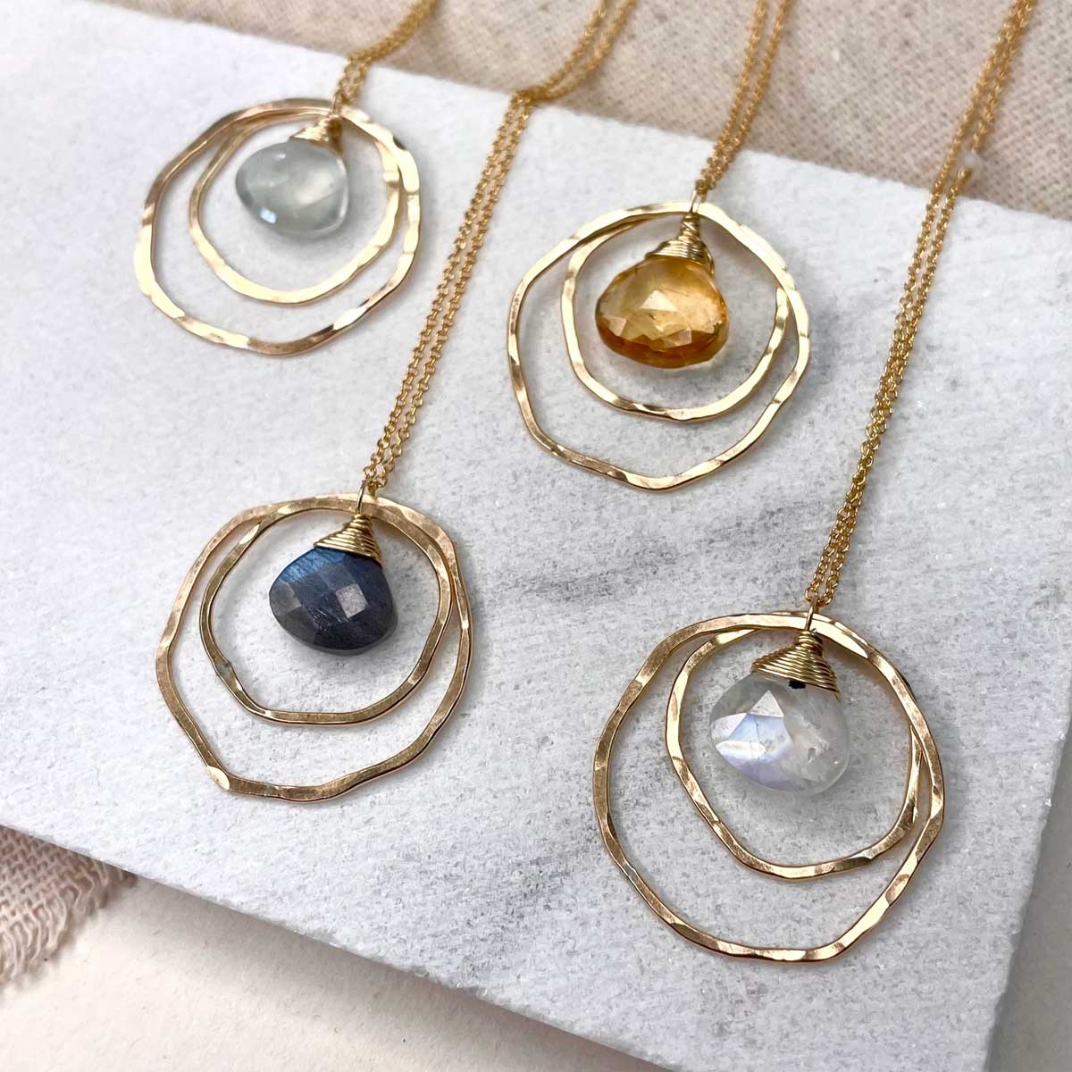 Group of hammered double-circle necklaces with gemstones; citrine option shown top right