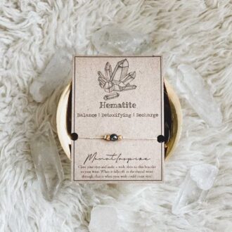 Hematite crystal wish bracelet on hemp cord with gold beads and kraft card packaging.
