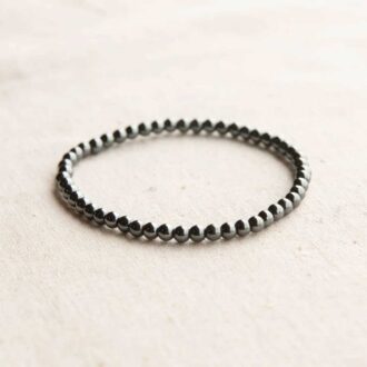 Hematite energy bracelet made of polished gemstone beads strung on a stretch cord, symbolizing courage and clarity.