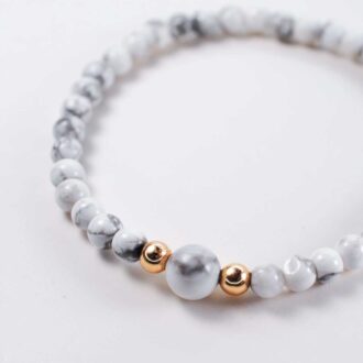 White howlite gemstone horizon bracelet with gold filled bead accents, 6.5-inch elastic design for calm and clarity.