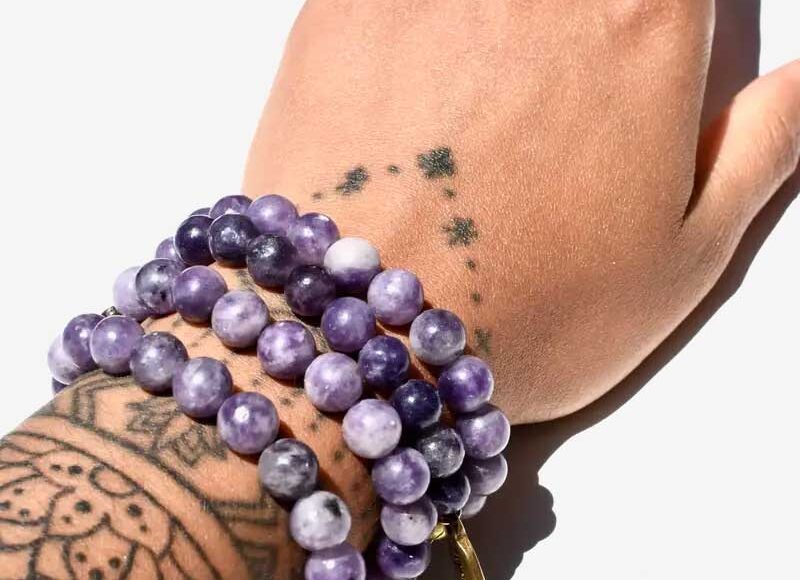 Lepidolite beaded bracelet with deep purple tones, worn stacked for calming energy and stress relief.