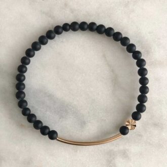 Ray of Light Bracelet with matte black onyx beads, gold-filled bar, and starburst bead.