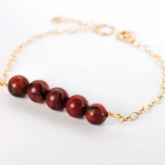 Red Jasper Genesis Bracelet with polished red jasper beads and a 14k gold-filled chain.