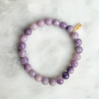 Lepidolite gemstone bracelet with 8mm lavender beads and gold accent charm, crafted for calming energy and stress relief.