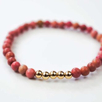 Rhodonite Ascension bracelet with pink gemstone beads and five gold-filled accent beads on a white background.