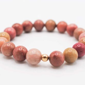 Rhodonite Solo Grande bracelet with large pink gemstone beads and a single gold-filled accent bead on a white background.