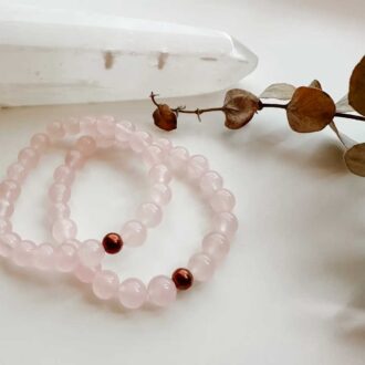 Rose quartz beaded bracelet with a single 6 mm bronze center bead on elastic