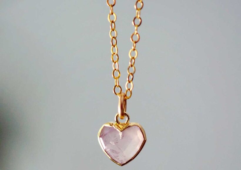 Rose quartz heart pendant set in gold on a delicate chain.
