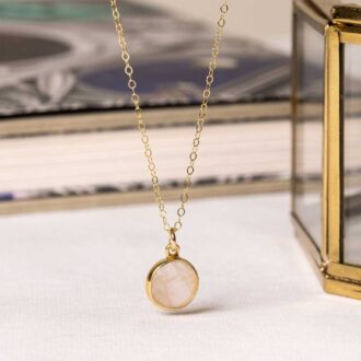 Rose quartz small circle pendant necklace on a delicate gold chain.