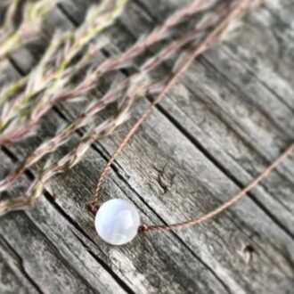 Minimalist selenite round gemstone necklace on light brown cord with sterling silver clasp, 18-inch length, designed for serenity and balance.