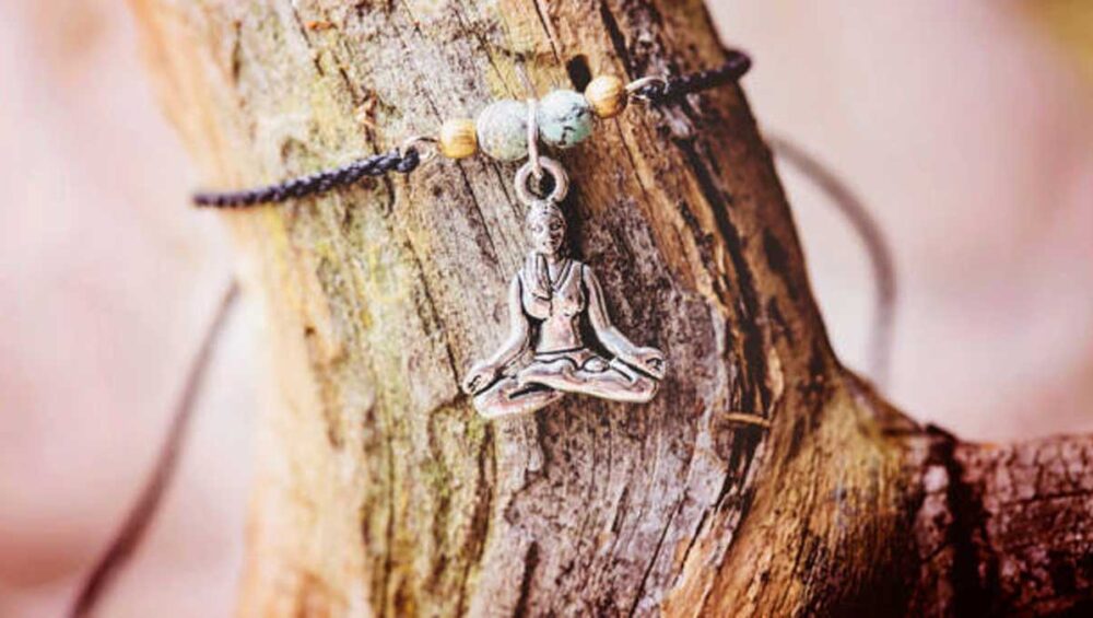Grounding bracelet with meditation charm on tree bark
