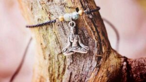 Grounding bracelet with meditation charm on tree bark