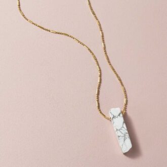 White howlite crystal point necklace on a gold beaded chain, designed for calm, clarity, and spiritual balance.